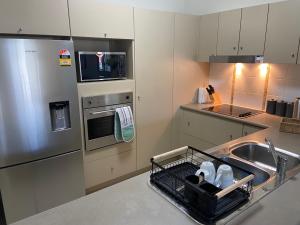 汤斯维尔Lakeside Central Apartment的厨房配有水槽和碗碟干燥架