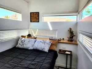 Apple ValleyDesigner Modern Tiny Home w All of The Amenities的一间小卧室,配有床和2个窗户