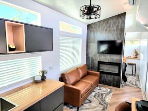Apple ValleyDesigner Modern Tiny Home w All of The Amenities的客厅配有棕色真皮沙发和壁炉