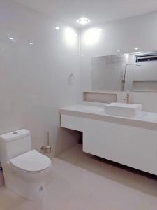PañgeABIZA Homestay的白色的浴室设有卫生间和水槽。