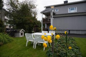 皮耶塔尔萨里Mukava kellarihuoneisto jossa sauna ja poreallas的院子里的白色桌子和椅子,花色黄