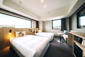 小樽OMO5 Otaru by Hoshino Resorts的酒店客房设有两张床和电视。