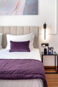 雅典Athens Flair的一间卧室配有一张带紫色枕头的床