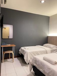 怡保Fresh Hotel的客房设有两张床、一张桌子和镜子