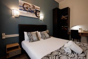 卡尔卡松阿斯托利亚酒店的一间卧室配有带白色床单和枕头的床。
