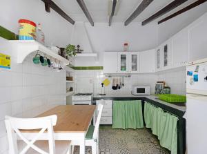 拉拉古纳Casa Julia的厨房配有白色橱柜和木桌