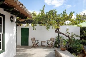 拉拉古纳Casa Julia的一个带椅子和绿门的庭院