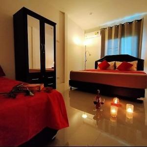 迈考海滩Orchidilla Residence Phuket Mai Khao Beach - SHAPlus的卧室配有两张床,地板上设有蜡烛