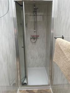 BrynmeninPen-Y-Bryn Annex的浴室里设有玻璃门淋浴