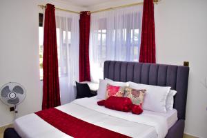 基苏木Rozy Penthouse的一间卧室配有一张带红色窗帘的大床