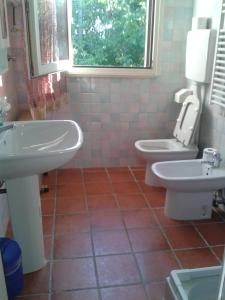 MaioloB&B Le Due Rocche的一间带两个盥洗盆、卫生间和窗户的浴室