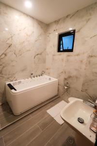 布桑加Josefina's Tourist Inn的白色的浴室设有浴缸和水槽。