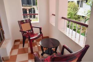 科钦Sithara Homestay Fort Cochin的一间设有两把椅子、一张桌子和一个窗户的房间