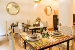 马拉喀什里亚德阿姆拉酒店的一间带桌椅和镜子的用餐室