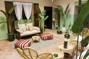 马拉喀什里亚德阿姆拉酒店的客厅配有沙发、椅子和植物