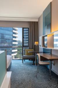 马普托马普托丽笙酒店的酒店客房配有一张床、一张书桌和一张书桌。