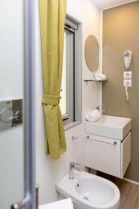 蒙泰斯库达伊奥hu Montescudaio Village的浴室设有黄色的淋浴帘和水槽