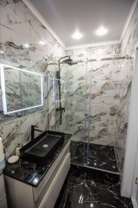 EkibastuzEl-Tau的一间带水槽和玻璃门淋浴的浴室