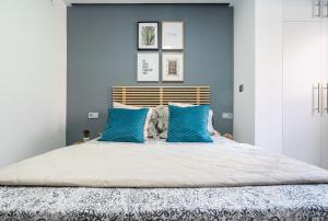 阿尔巴塞特Apartamento Mani en Avenida España con terraza的一间卧室拥有蓝色的墙壁,配有一张带蓝色枕头的床。