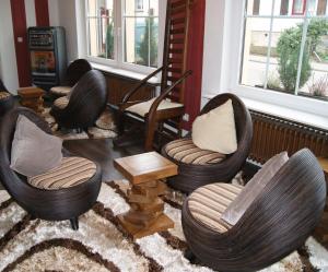 莱巴赫Hotel-Restaurant Bürgerstuben的客厅配有三把椅子和地毯