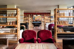 卡兹贝吉卡兹别吉客房酒店的图书馆,藏有两把椅子和书架