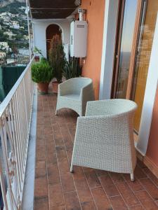 波西塔诺La Casa di Nunzia B&B的阳台配有2把藤椅和加热器