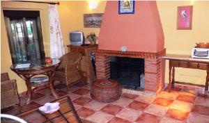 Zalamea la RealCortijo Zalamea的客厅设有砖砌壁炉和桌子