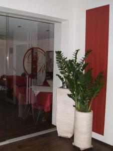 莱巴赫Hotel-Restaurant Bürgerstuben的用餐室旁白色花瓶里的植物