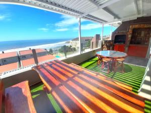 马盖特Beach Splendor @ 24 La Crete Sands的阳台的长凳,配有桌子和海滩