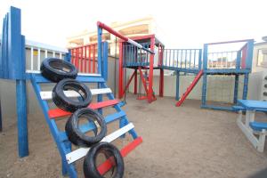 乌旺戈海滩Saints View Resort Unit 5的游乐场,上面有梯子,上面有轮胎