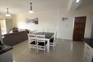 乌旺戈海滩Saints View Resort Unit 9的厨房以及带桌椅的起居室。