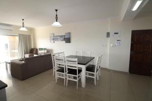 乌旺戈海滩Saints View Resort Unit 12的用餐室以及带桌椅的起居室。