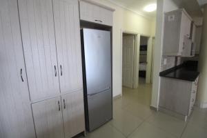 乌旺戈海滩Saints View Resort Unit 12的厨房配有白色橱柜和冰箱。