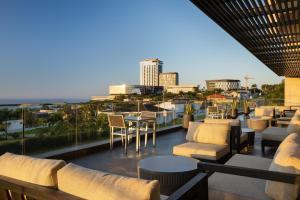 德班Premier Hotel Umhlanga的一个带桌椅的屋顶露台,享有城市天际线
