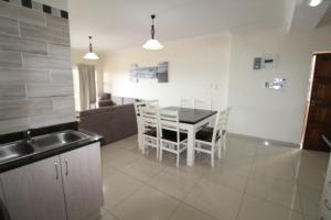 乌旺戈海滩Saints View Resort Unit 21的厨房以及带桌椅的起居室。