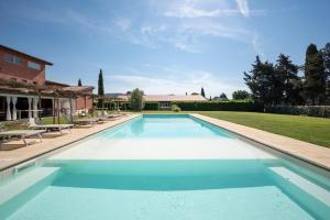 布拉卡尼Guadalupe Tuscany Resort的庭院里的大型游泳池,配有椅子