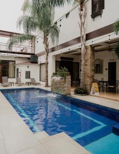 瓜亚基尔Hotel Patrimonial by Greenfield的一座棕榈树游泳池和一座建筑