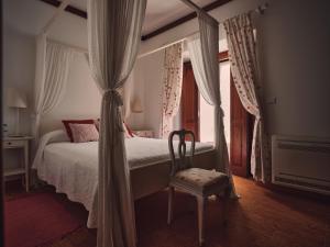 圣塔伦Quinta Dos Anjos的一间卧室配有一张带椅子的床和一扇窗户