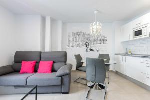 大加那利岛拉斯帕尔马斯Vegueta Luxury Apartments的客厅配有沙发和带粉红色枕头的桌子。