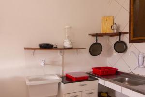 凯鲁Casa do Pepe的厨房配有水槽和带锅碗瓢盆的台面