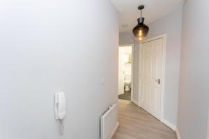 曼彻斯特Pillo Rooms Serviced Apartments - Trafford的走廊上的门,墙上有电话