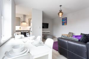 曼彻斯特Pillo Rooms Serviced Apartments - Trafford的客厅配有白色桌子和沙发