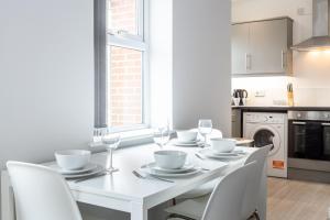曼彻斯特Pillo Rooms Serviced Apartments - Trafford的白色的用餐室配有白色的桌椅