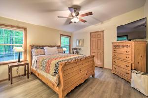 BirchwoodTranquil Cabin Getaway Near Red Cedar Lake!的一间卧室配有一张床和吊扇