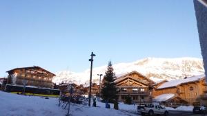 于埃Studio des Jeux - Alpe d'Huez Hyper Centre - 4-5 personnes - Wifi的雪覆盖的山地的滑雪小屋