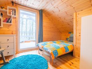 DomysłówCzerwone Domki的小木屋内的卧室,配有床和窗户