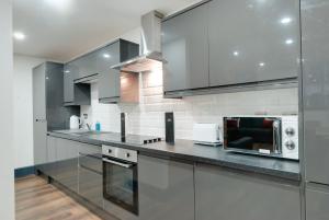 利物浦Harrisons Aparthotel Liverpool的厨房配有不锈钢橱柜和微波炉