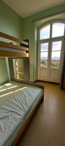 马赛Auberge de Jeunesse HI Marseille Bois-Luzy的一间卧室设有一张床和一个大窗户