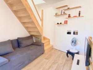 普瓦捷- Le Lys - Magnifique maisonnette avec terrasse的带沙发和木地板的客厅