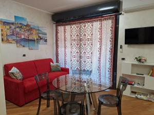 热那亚La casa sul molo - Acquario的客厅配有红色的沙发和玻璃桌